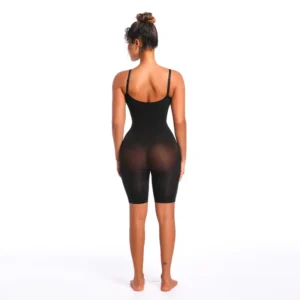 Black woman posing and wearing a black mid-thigh bodysuit facing her backside over a white background
