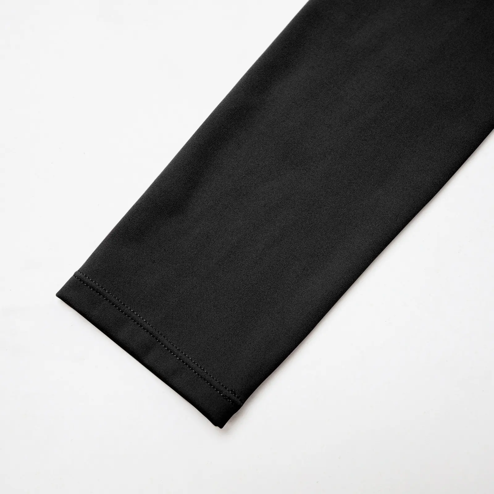 CALIFLO Activewear High-Compression Long Sleeve Crew Cut Bodysuit black Close-up of black long sleeve bodysuit sleeve over a white background