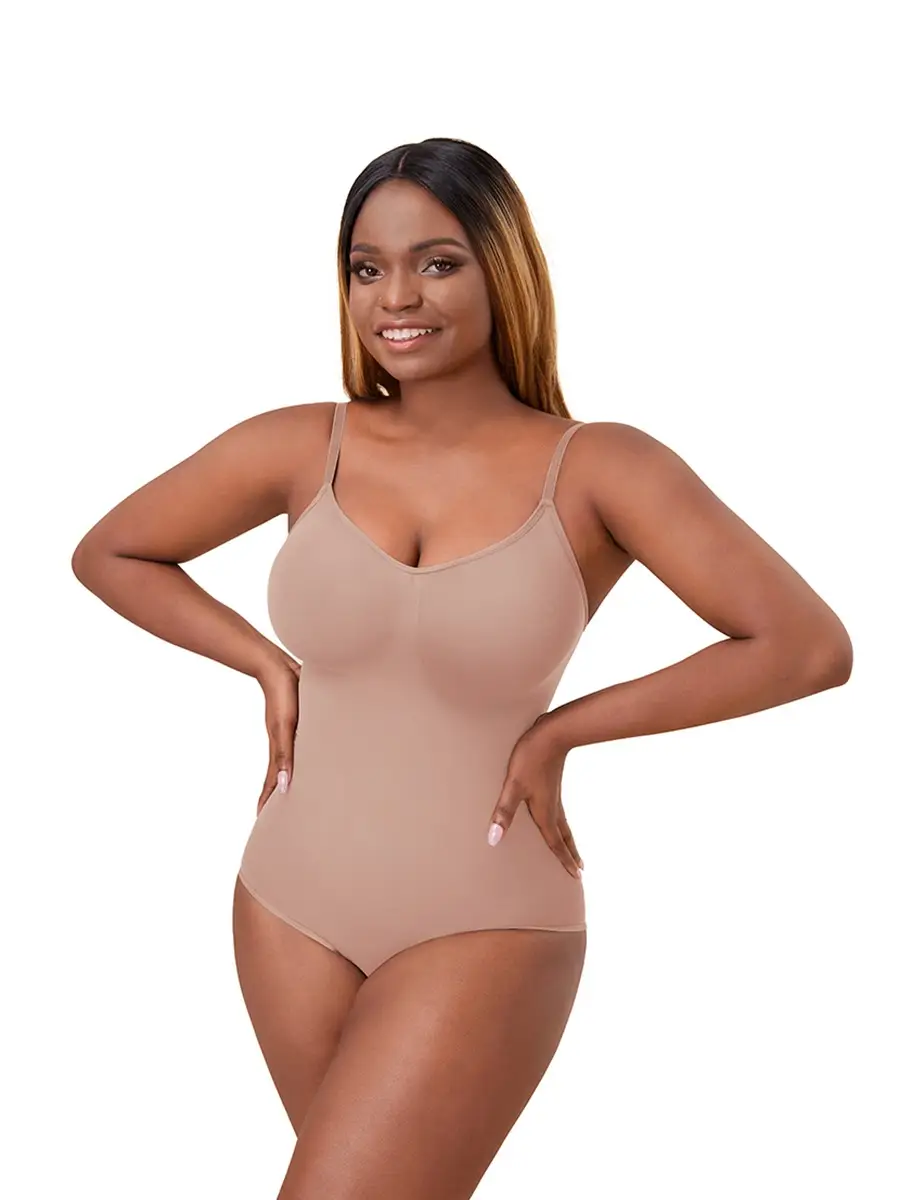 Black woman posing and wearing a beige brief bodysuit over a white background