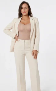 Hispanic woman wearing califlo classic body shaper brief in beige with cream suit